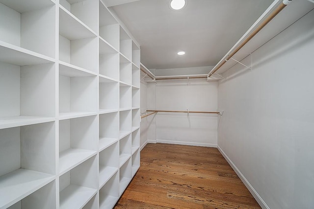 walk in closet with wood finished floors