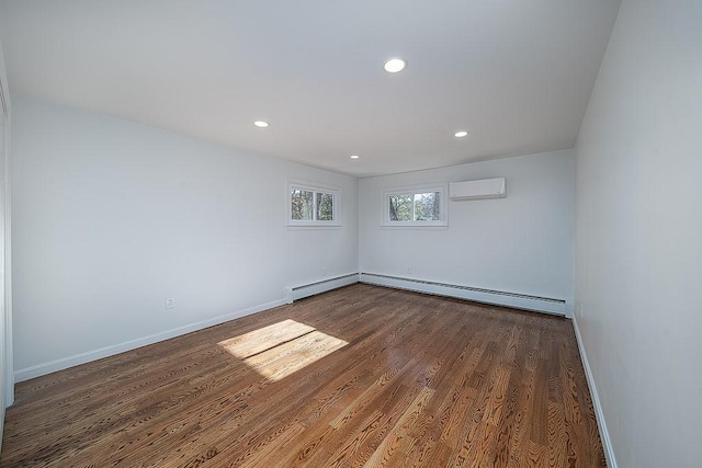 empty room with dark hardwood / wood-style flooring, a baseboard heating unit, and a wall unit AC