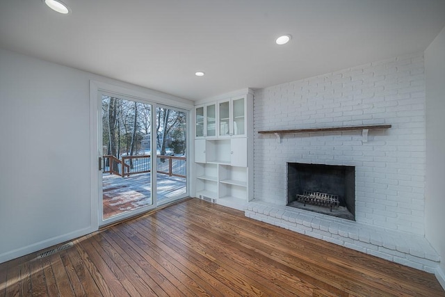 unfurnished living room with visible vents, dark wood-type flooring, baseboards, recessed lighting, and a fireplace