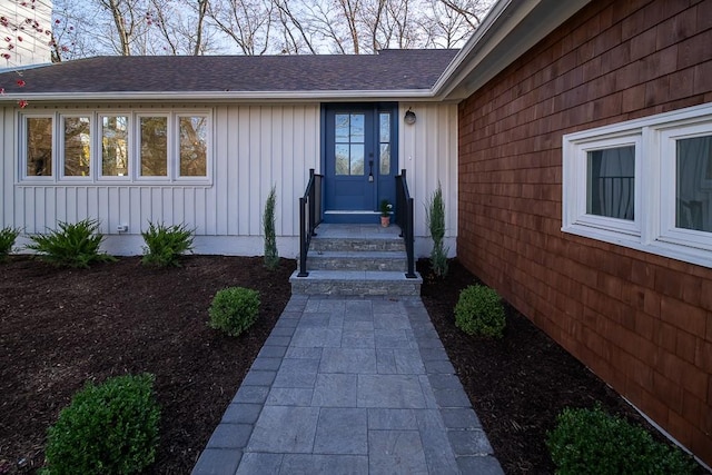 property entrance with roof with shingles and board and batten siding