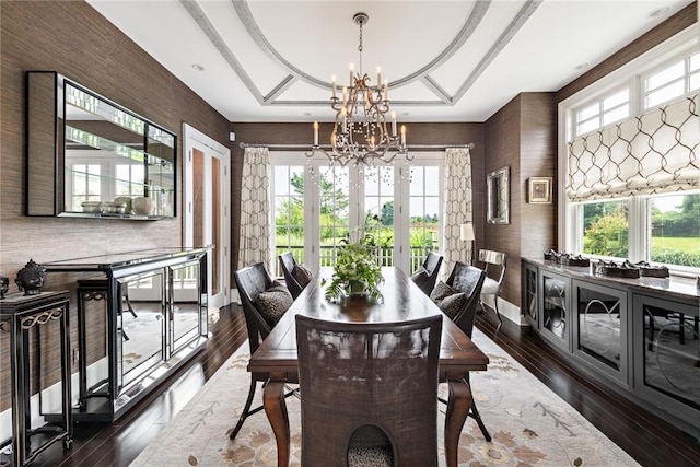 dining space with dark hardwood / wood-style flooring, a notable chandelier, and french doors