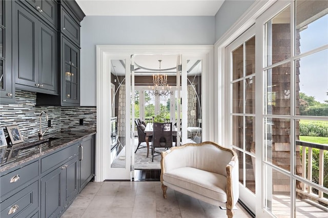 kitchen featuring tasteful backsplash, dark stone countertops, and a notable chandelier