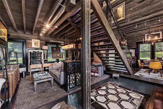 living room featuring wood walls, an inviting chandelier, wooden ceiling, beamed ceiling, and a healthy amount of sunlight