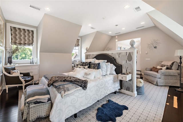 bedroom with multiple windows, lofted ceiling with skylight, and hardwood / wood-style flooring