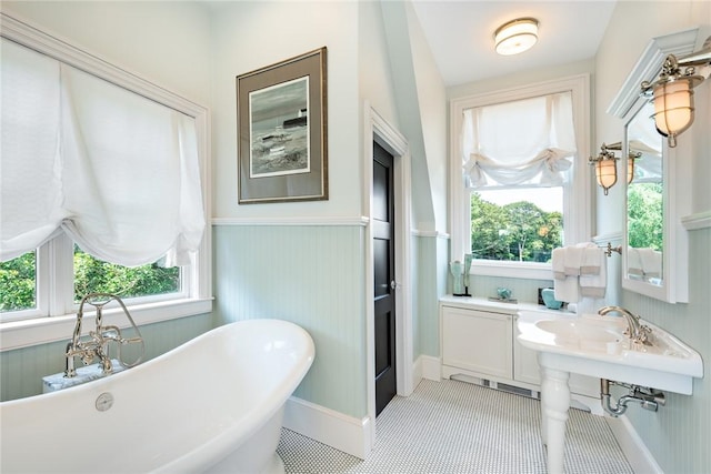 bathroom with tile patterned flooring and a bath