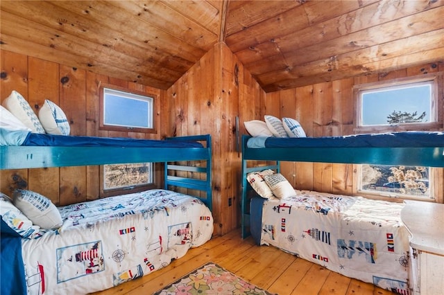 bedroom featuring hardwood / wood-style flooring, wooden walls, wooden ceiling, and vaulted ceiling