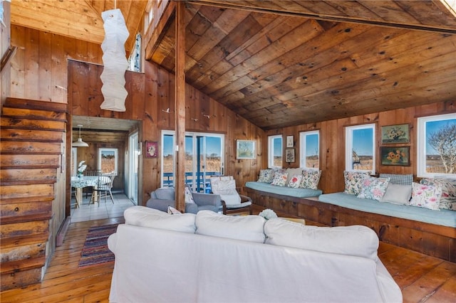 living room featuring hardwood / wood-style flooring, wooden ceiling, vaulted ceiling, and wood walls