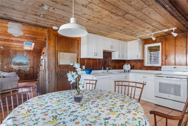 kitchen featuring wood ceiling, white appliances, wooden walls, and white cabinets