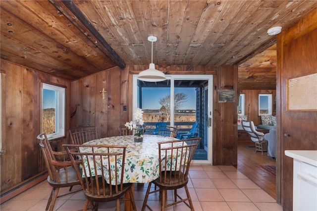 tiled dining area featuring wood ceiling, baseboard heating, vaulted ceiling, and wood walls