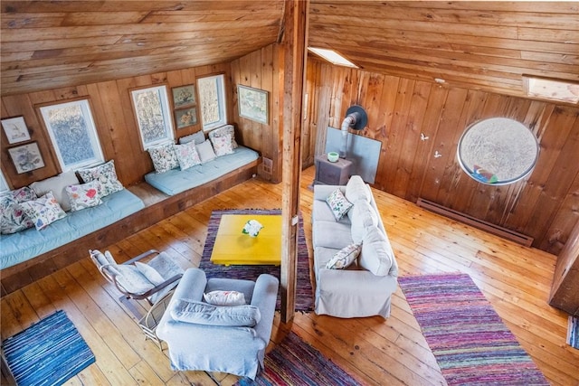 living room with wood walls, lofted ceiling, hardwood / wood-style flooring, a baseboard heating unit, and wooden ceiling