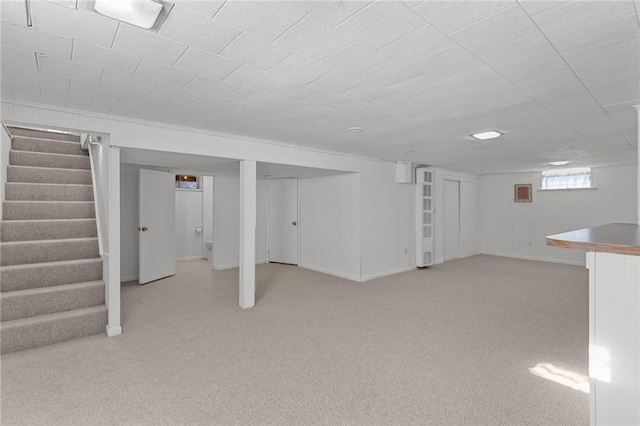 basement featuring light colored carpet