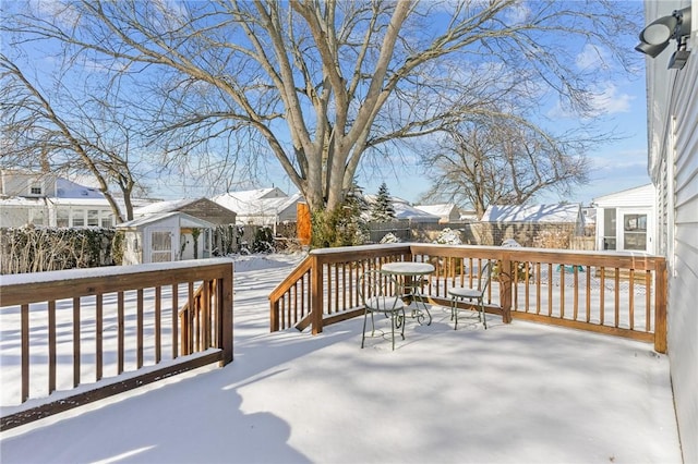 snow covered deck featuring a storage shed