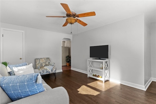 living room featuring ceiling fan and dark hardwood / wood-style floors