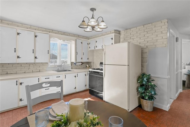 kitchen featuring decorative light fixtures, white cabinetry, sink, backsplash, and white appliances