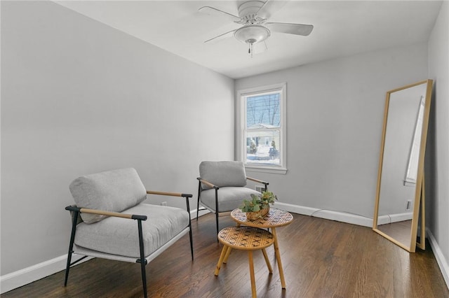 living area featuring dark hardwood / wood-style floors and ceiling fan