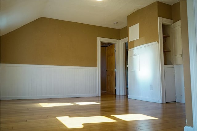 unfurnished room with lofted ceiling and light hardwood / wood-style floors