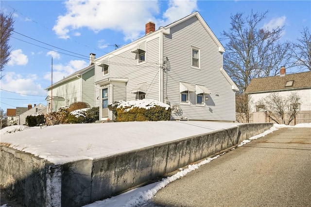 view of snow covered back of property