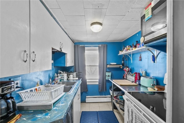 kitchen featuring a baseboard radiator, sink, and light tile patterned floors