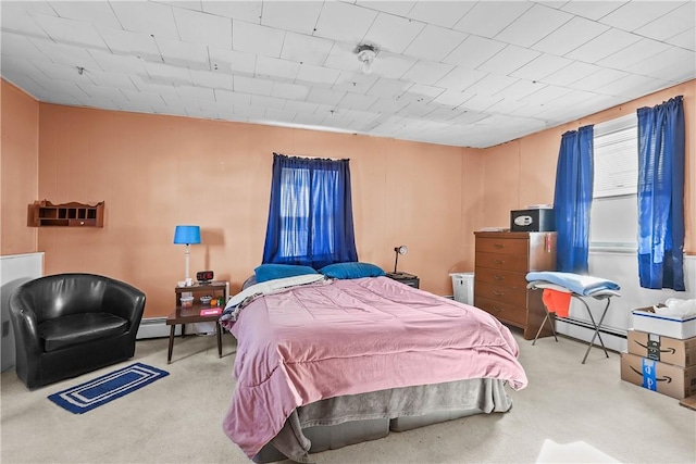 bedroom with light carpet and baseboard heating