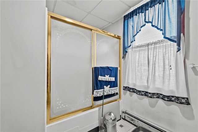 bathroom featuring a paneled ceiling, enclosed tub / shower combo, and a baseboard radiator