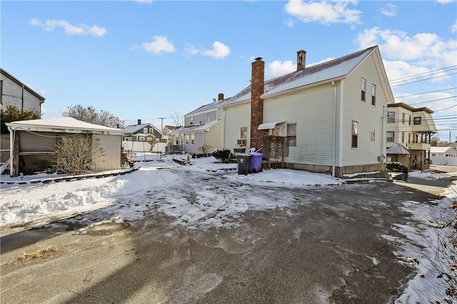 view of snow covered back of property