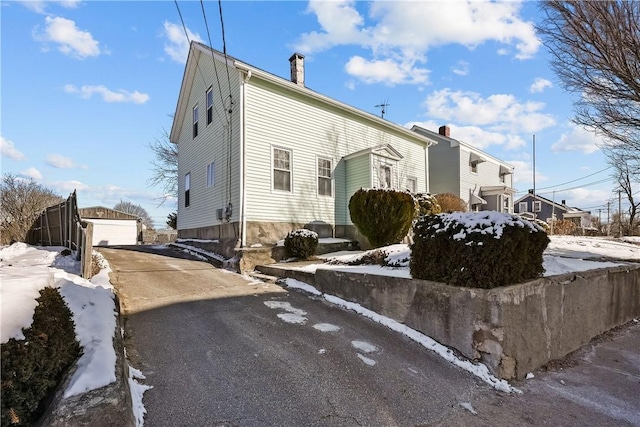 snow covered property with a garage