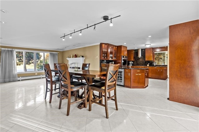 tiled dining area with wine cooler, a baseboard radiator, ornamental molding, and track lighting