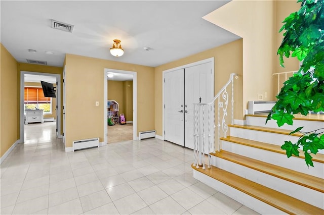 foyer entrance with light tile patterned floors and baseboard heating