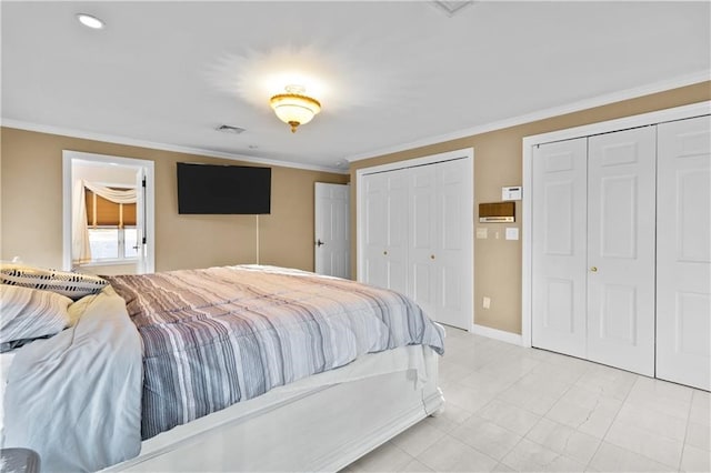 bedroom featuring crown molding and multiple closets