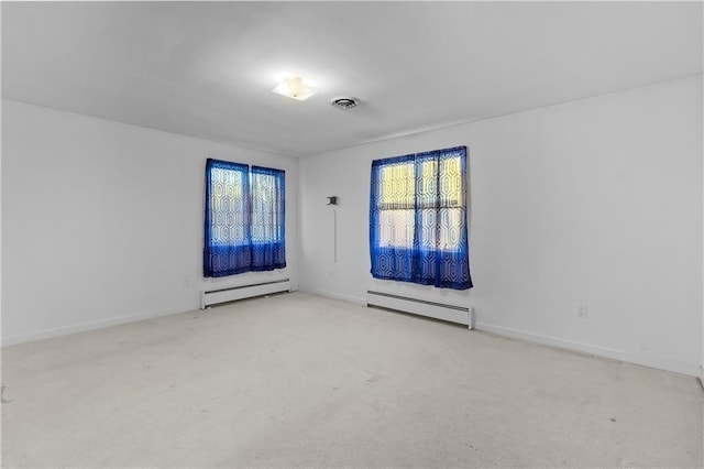 carpeted spare room with a baseboard radiator