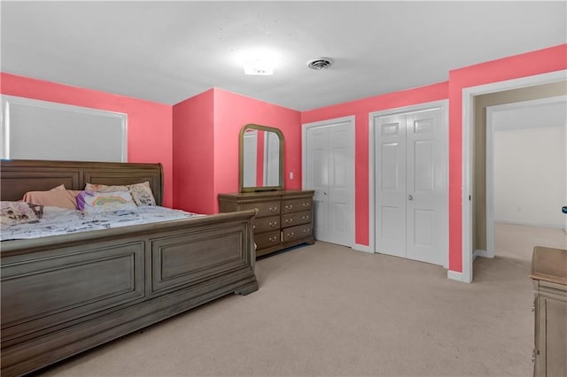 carpeted bedroom featuring multiple closets