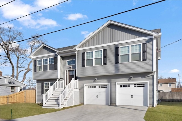 raised ranch featuring a garage and a front lawn