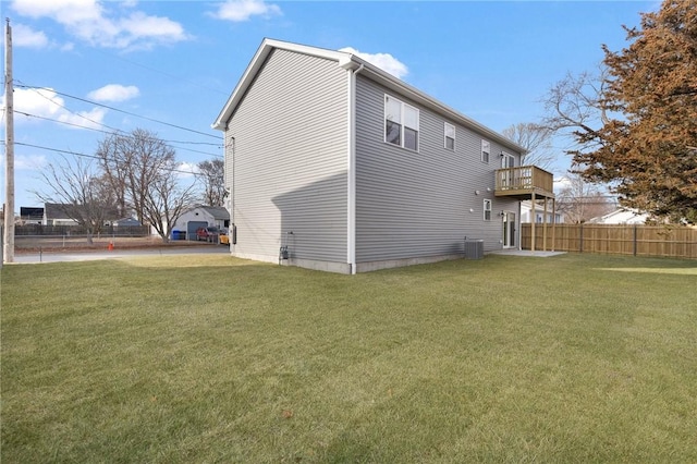 rear view of house with a yard, a balcony, and central air condition unit