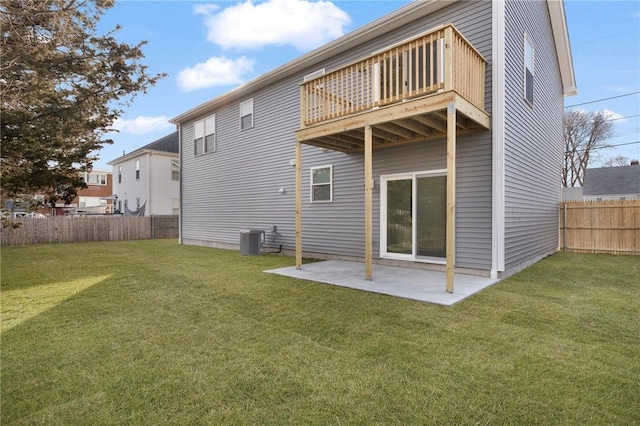 rear view of house featuring a yard, central AC, a balcony, and a patio area