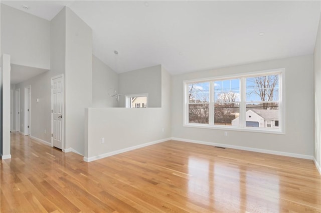 empty room with lofted ceiling and light hardwood / wood-style flooring