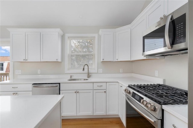 kitchen featuring sink, white cabinets, and appliances with stainless steel finishes