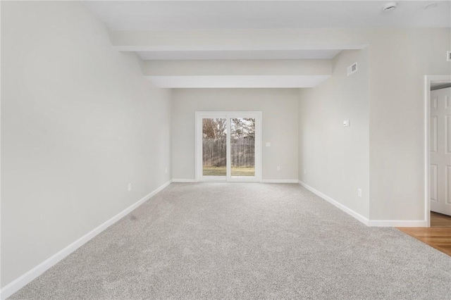 unfurnished room featuring beamed ceiling and carpet floors