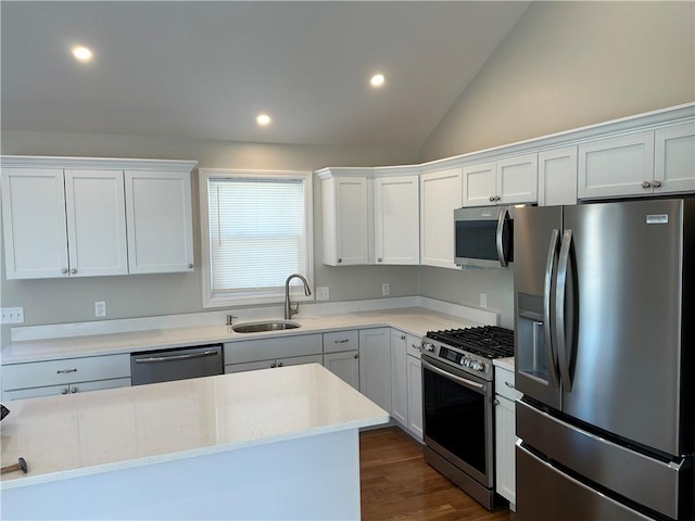 kitchen featuring lofted ceiling, sink, white cabinetry, appliances with stainless steel finishes, and dark hardwood / wood-style flooring