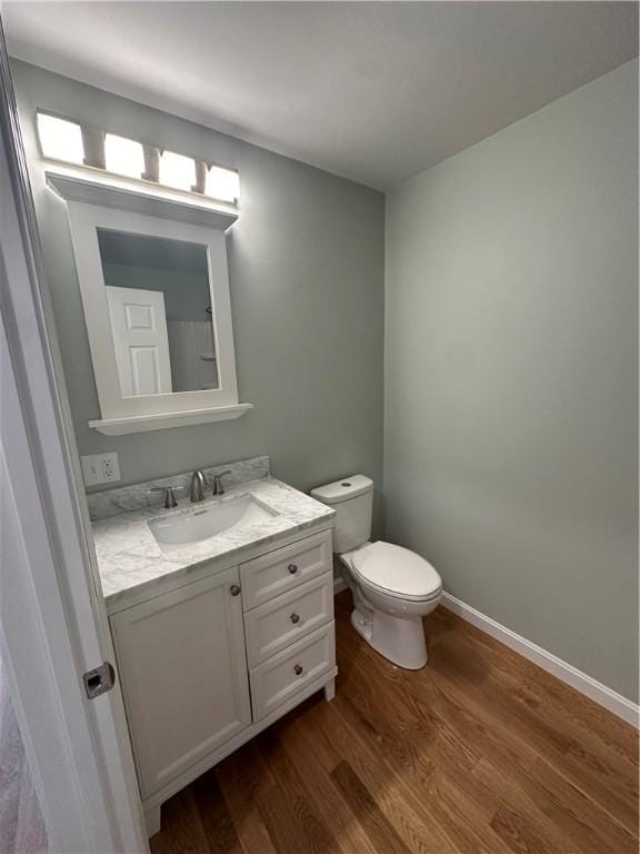 bathroom featuring vanity, wood-type flooring, and toilet