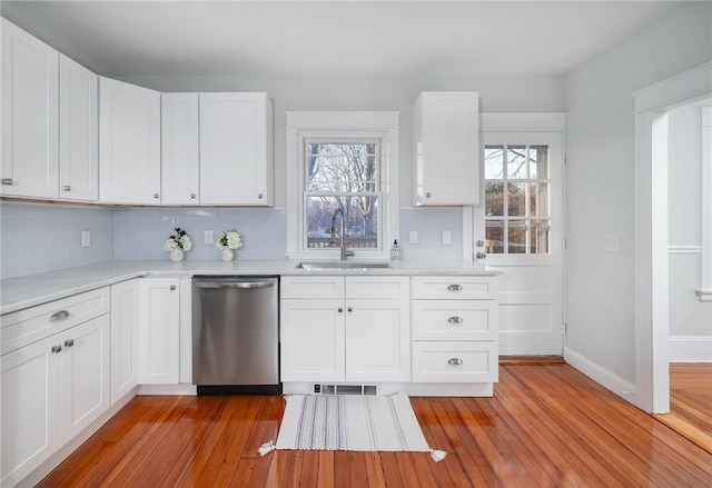 kitchen featuring dishwasher, sink, and white cabinets