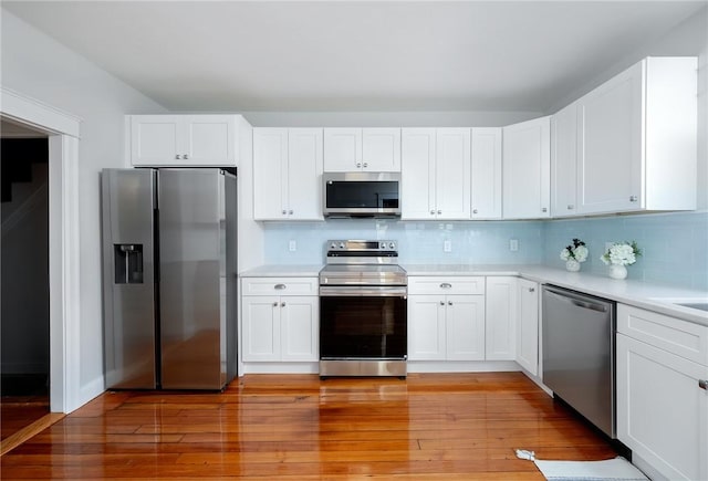 kitchen featuring white cabinetry, stainless steel appliances, and light wood-type flooring