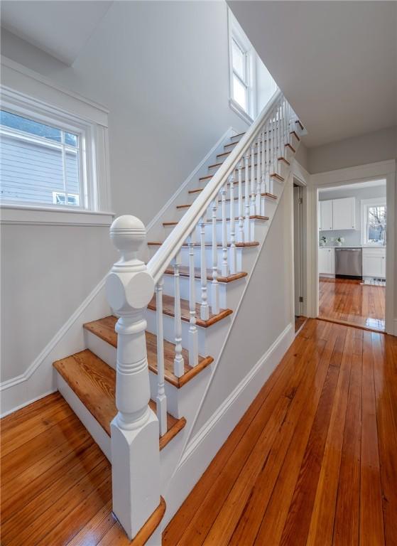 stairway featuring plenty of natural light and hardwood / wood-style floors