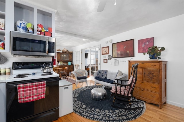 kitchen featuring ceiling fan, a textured ceiling, light hardwood / wood-style flooring, and electric range