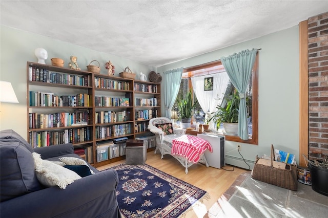 sitting room featuring a baseboard heating unit, a textured ceiling, and light hardwood / wood-style floors