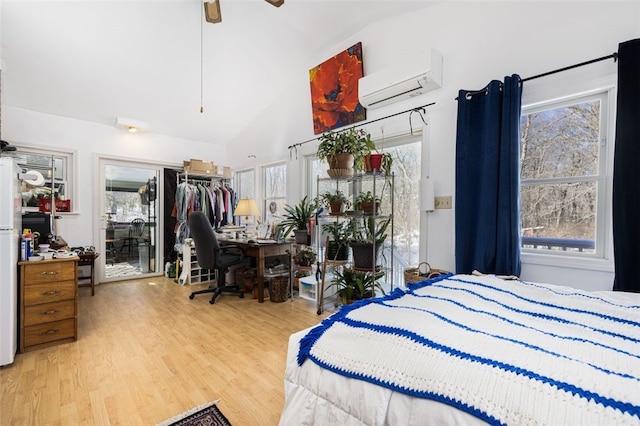 bedroom featuring vaulted ceiling, a wall mounted AC, hardwood / wood-style floors, and multiple windows