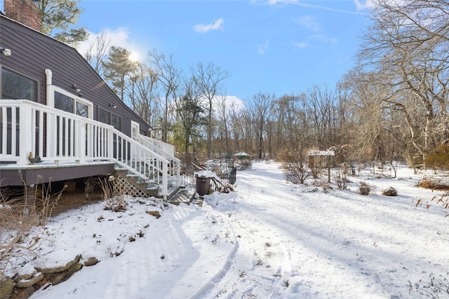 yard covered in snow featuring a deck