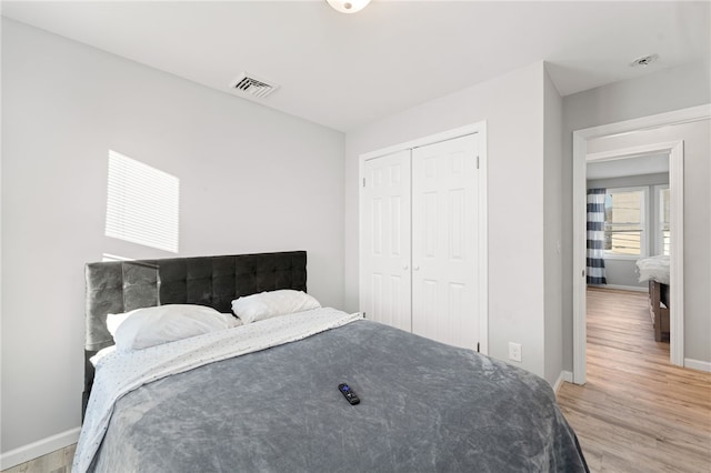 bedroom with light hardwood / wood-style flooring and a closet