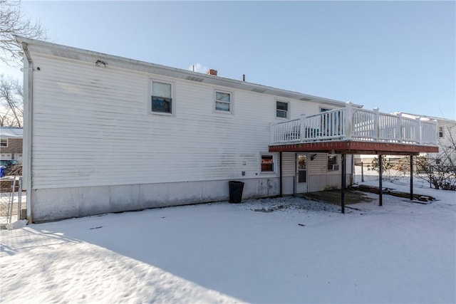 snow covered property with a wooden deck