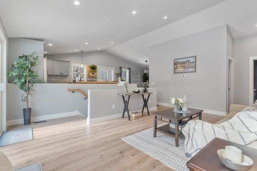 living room with lofted ceiling and light hardwood / wood-style flooring