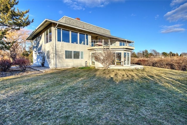 rear view of house featuring a yard, a patio, and a balcony